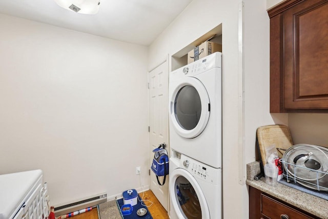 laundry area with laundry area, stacked washing maching and dryer, and baseboard heating