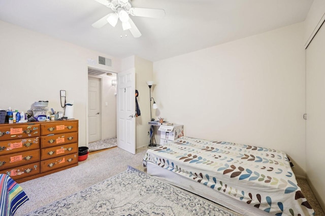 carpeted bedroom featuring a ceiling fan and visible vents