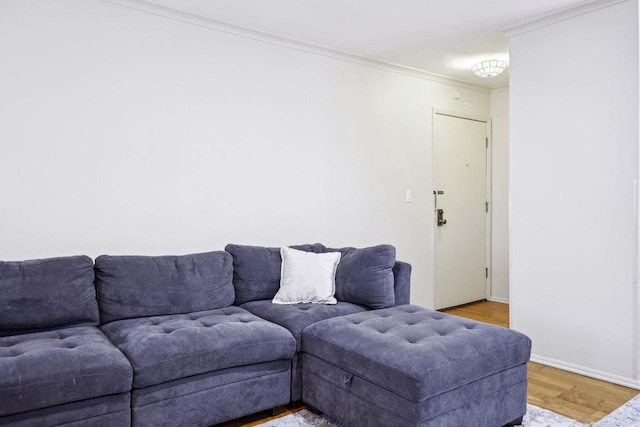 living area featuring baseboards, ornamental molding, and light wood finished floors