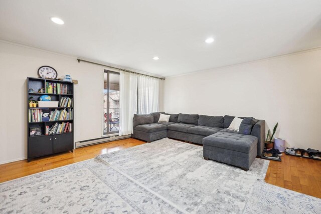 living area featuring ornamental molding, a baseboard heating unit, recessed lighting, and wood finished floors