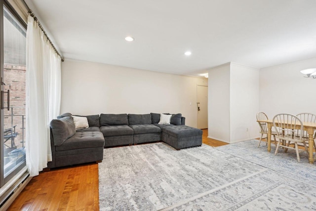 living room with recessed lighting, a baseboard radiator, baseboards, and wood finished floors