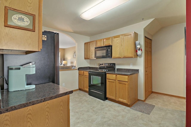 kitchen with dark countertops, black appliances, and arched walkways