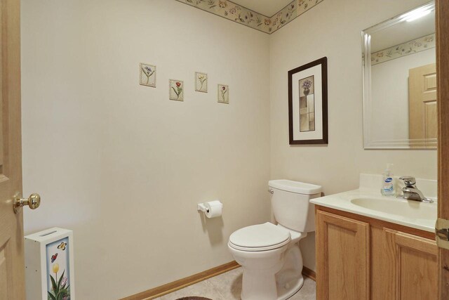 bathroom with toilet, baseboards, tile patterned floors, and vanity