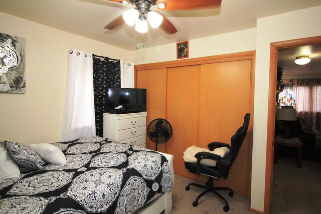 carpeted bedroom featuring a closet and a ceiling fan