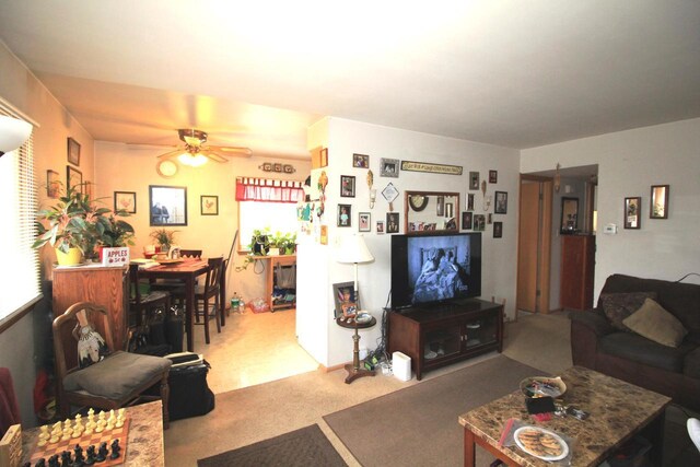 carpeted living room with a ceiling fan