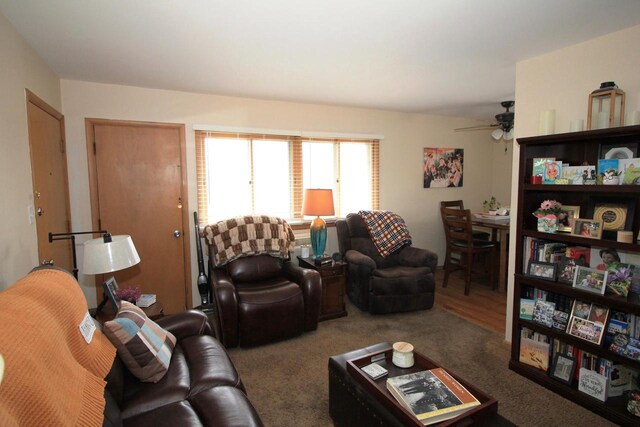 carpeted living room featuring a ceiling fan