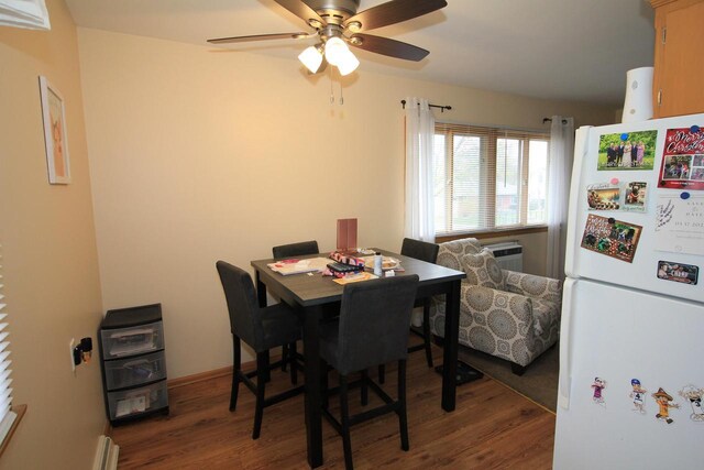dining space with ceiling fan, wood finished floors, and a wall mounted air conditioner