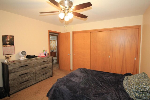 bedroom featuring ceiling fan, light colored carpet, and a closet