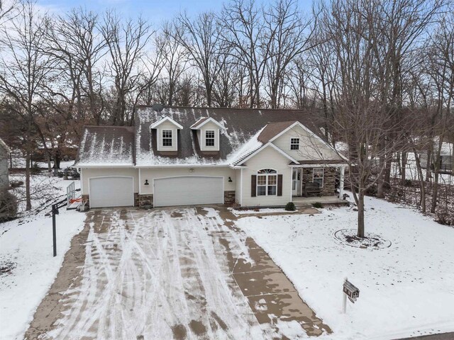 view of front of home with an attached garage, a porch, driveway, and stone siding