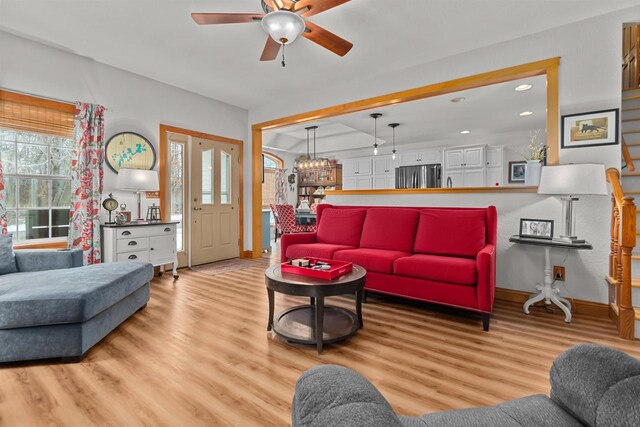 living area with baseboards, ceiling fan with notable chandelier, recessed lighting, and wood finished floors