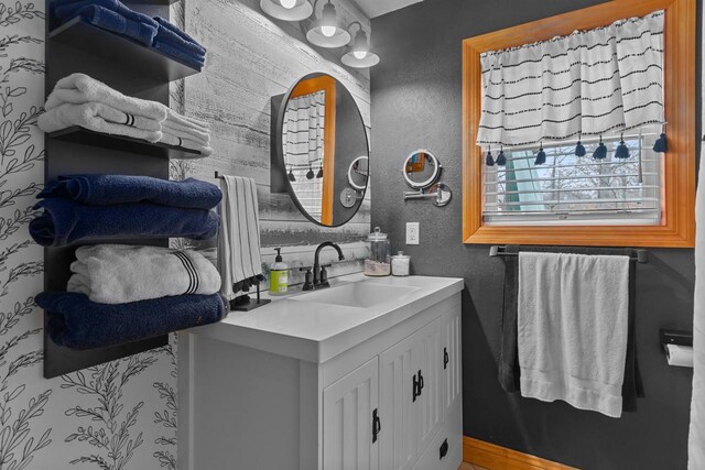 bathroom featuring a textured wall and vanity