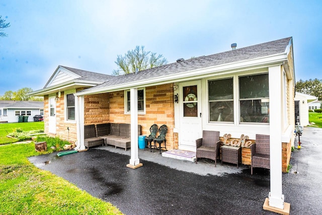 view of front of house featuring a shingled roof and stone siding