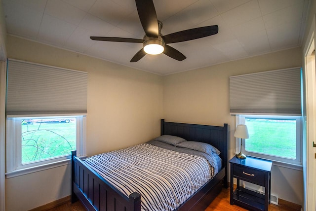 bedroom featuring baseboards, a ceiling fan, and wood finished floors