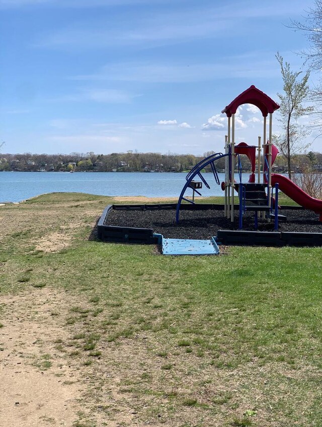 community play area with a lawn and a water view