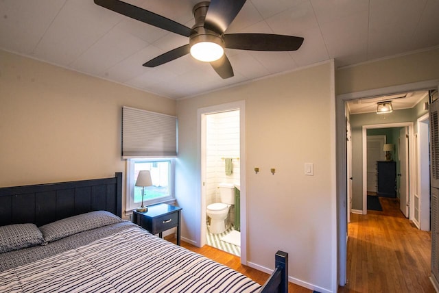 bedroom with baseboards, ornamental molding, and wood finished floors