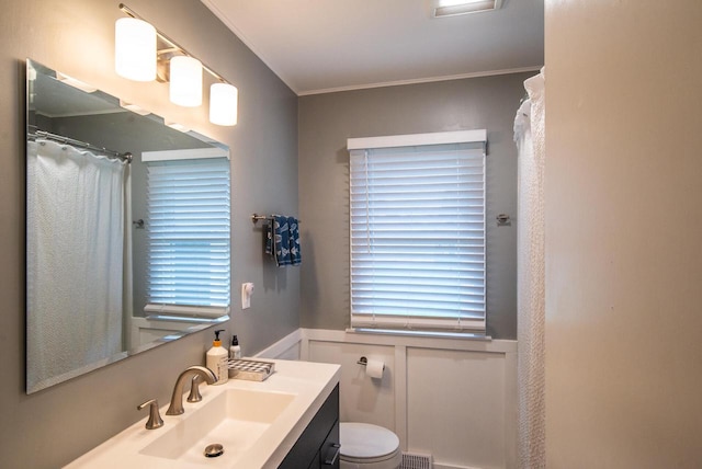 bathroom featuring vanity, toilet, curtained shower, visible vents, and ornamental molding