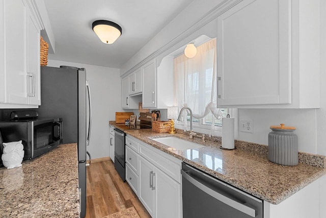 kitchen featuring stainless steel dishwasher, a sink, white cabinets, and electric stove