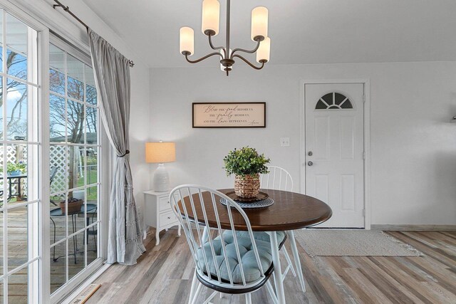 dining space featuring wood finished floors and a chandelier