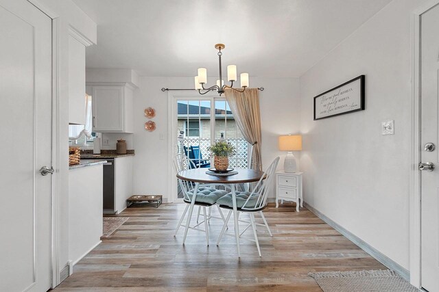 dining room featuring baseboards, a chandelier, and light wood-style flooring