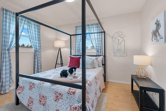 bedroom with baseboards and light wood finished floors