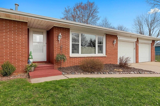 view of front of home featuring brick siding, an attached garage, a front yard, and concrete driveway