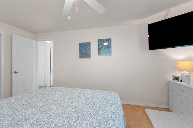 bedroom featuring baseboards, ceiling fan, and light wood-style floors
