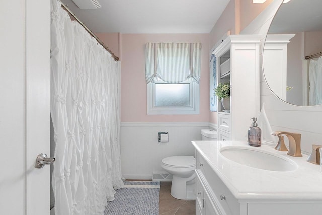 full bath featuring visible vents, tile patterned flooring, vanity, a wainscoted wall, and toilet