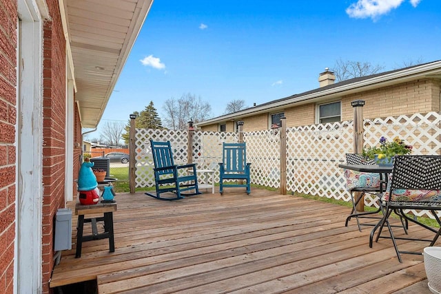wooden terrace featuring fence