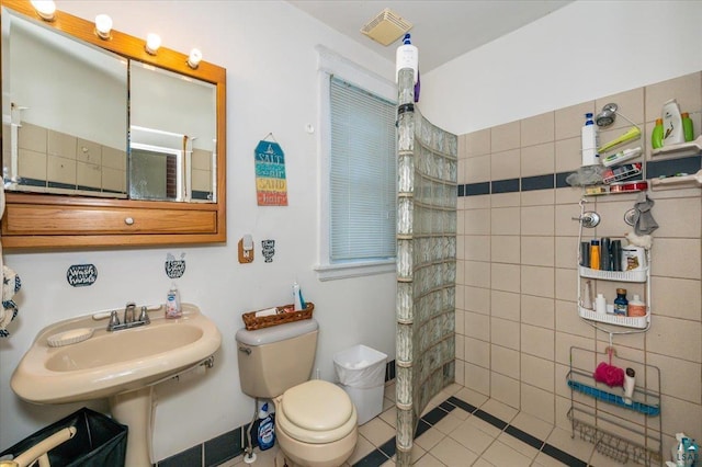 bathroom with a sink, a walk in shower, tile patterned floors, and toilet