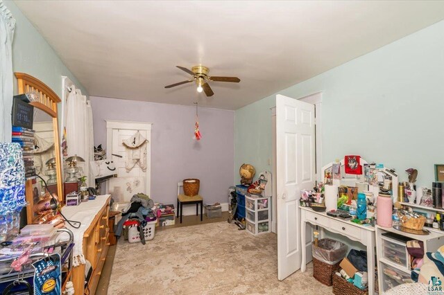 recreation room with ceiling fan and light carpet