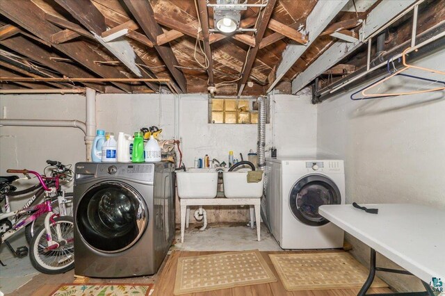 laundry area with separate washer and dryer, laundry area, and a sink