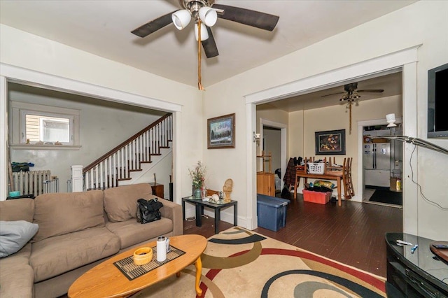 living area with a ceiling fan, stairway, wood finished floors, and radiator