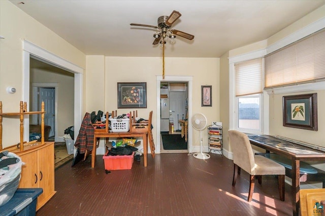 office area with a ceiling fan, baseboards, and wood finished floors