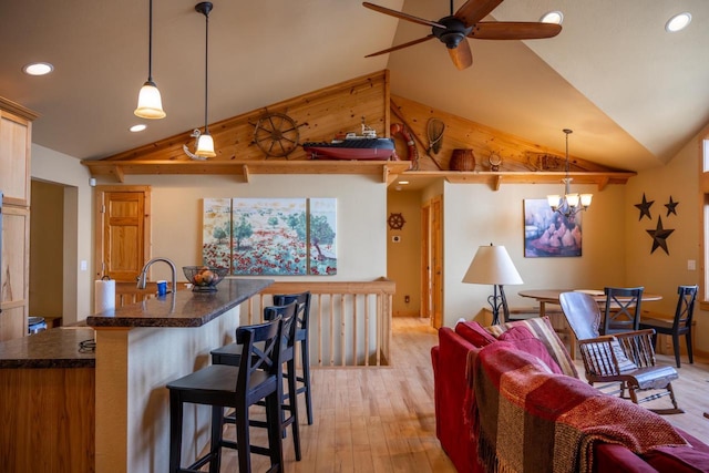 W5588 S Stone Gate Dr, New Lisbon, WI 53950 - living room with baseboards, ceiling fan with notable chandelier, lofted ceiling, light wood-style floors, and recessed lighting