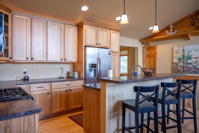 W5588 S Stone Gate Dr, New Lisbon, WI 53950 - kitchen featuring a kitchen bar, stainless steel refrigerator with ice dispenser, recessed lighting, light wood finished floors, and vaulted ceiling