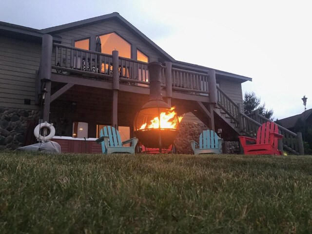 W5588 S Stone Gate Dr, New Lisbon, WI 53950 - rear view of property with stairs, a wooden deck, and stone siding
