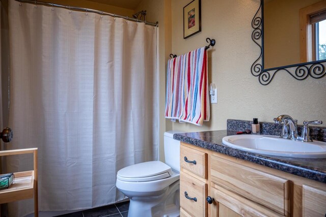 W5588 S Stone Gate Dr, New Lisbon, WI 53950 - bathroom featuring a textured wall, vanity, toilet, tile patterned floors, and curtained shower