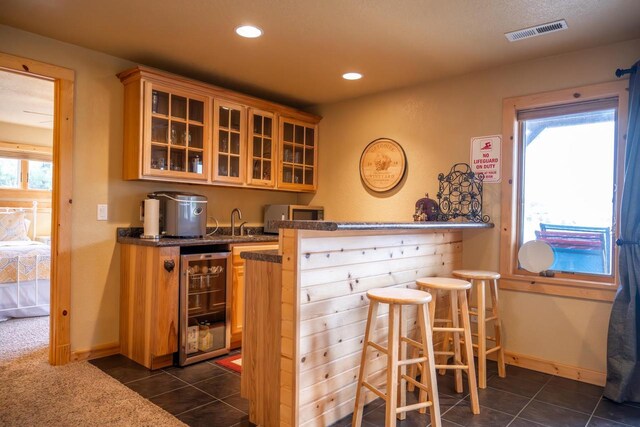 W5588 S Stone Gate Dr, New Lisbon, WI 53950 - bar with a healthy amount of sunlight, dark tile patterned floors, visible vents, stainless steel microwave, and beverage cooler