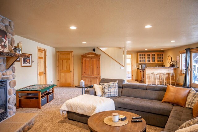 W5588 S Stone Gate Dr, New Lisbon, WI 53950 - carpeted living room featuring recessed lighting, a stone fireplace, and indoor bar