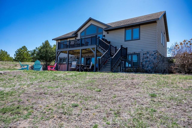 W5588 S Stone Gate Dr, New Lisbon, WI 53950 - rear view of house with stairway, a yard, a wooden deck, and stone siding