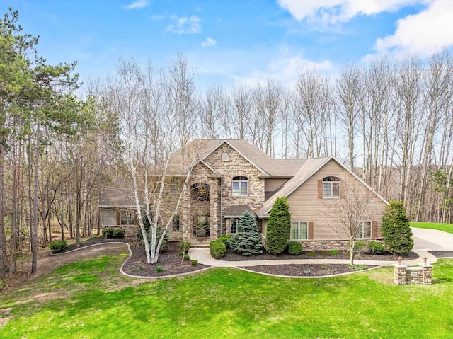 traditional home with a front yard and stone siding
