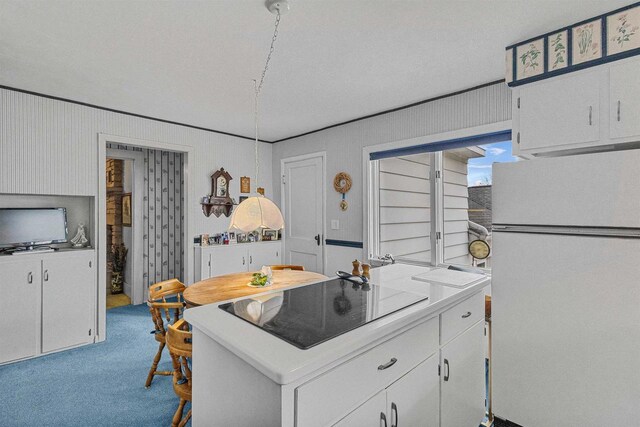 812 Milwaukee St, Kewaunee, WI 54216 - kitchen with freestanding refrigerator, light countertops, black electric cooktop, white cabinets, and carpet