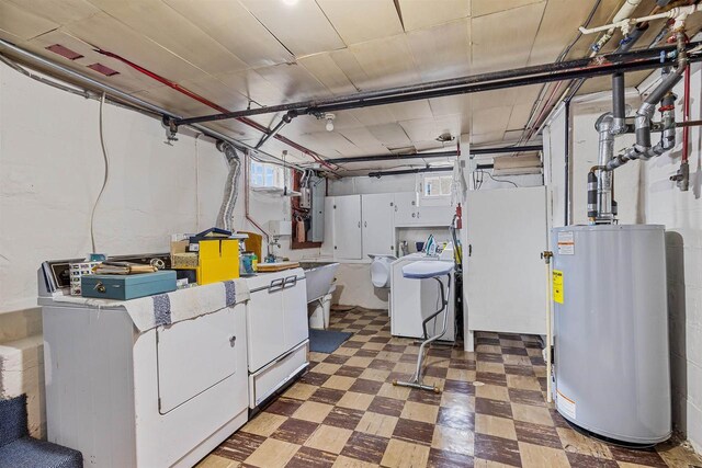 812 Milwaukee St, Kewaunee, WI 54216 - clothes washing area featuring washer and clothes dryer, cabinet space, water heater, and tile patterned floors