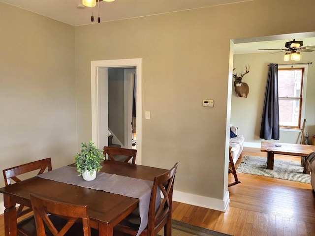 218 7th Ave, New Glarus, WI 53574 - dining area with stairway, baseboards, ceiling fan, and wood-type flooring