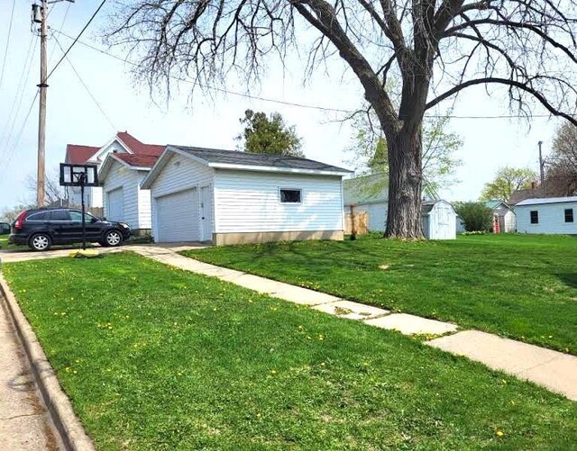 218 7th Ave, New Glarus, WI 53574 - view of yard featuring a detached garage, an outbuilding, and a storage unit