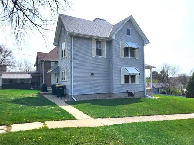 218 7th Ave, New Glarus, WI 53574 - view of property exterior with a shingled roof and a yard