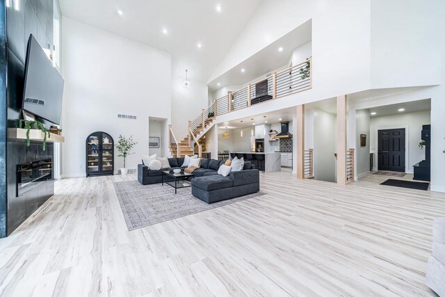 1810 White Dove Ln, Kaukauna, WI 54130 - living room featuring visible vents, stairs, wood finished floors, baseboards, and high vaulted ceiling