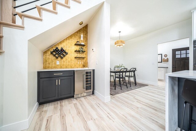 1810 White Dove Ln, Kaukauna, WI 54130 - bar featuring light wood-style floors, a dry bar, vaulted ceiling, and beverage cooler
