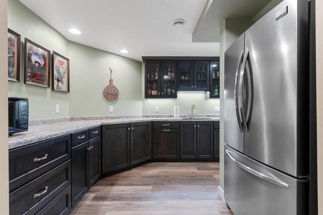 1881 Deer Trail Ct, Luxemburg, WI 54217 - kitchen featuring a sink, light wood finished floors, light countertops, freestanding refrigerator, and glass insert cabinets
