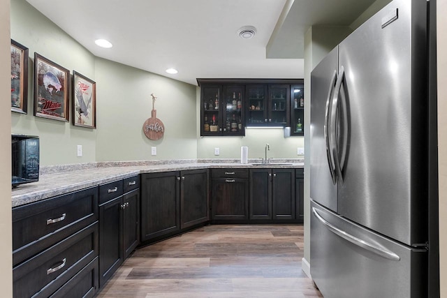 1881 Deer Trail Ct, Luxemburg, WI 54217 - kitchen featuring a sink, light wood finished floors, light countertops, freestanding refrigerator, and glass insert cabinets
